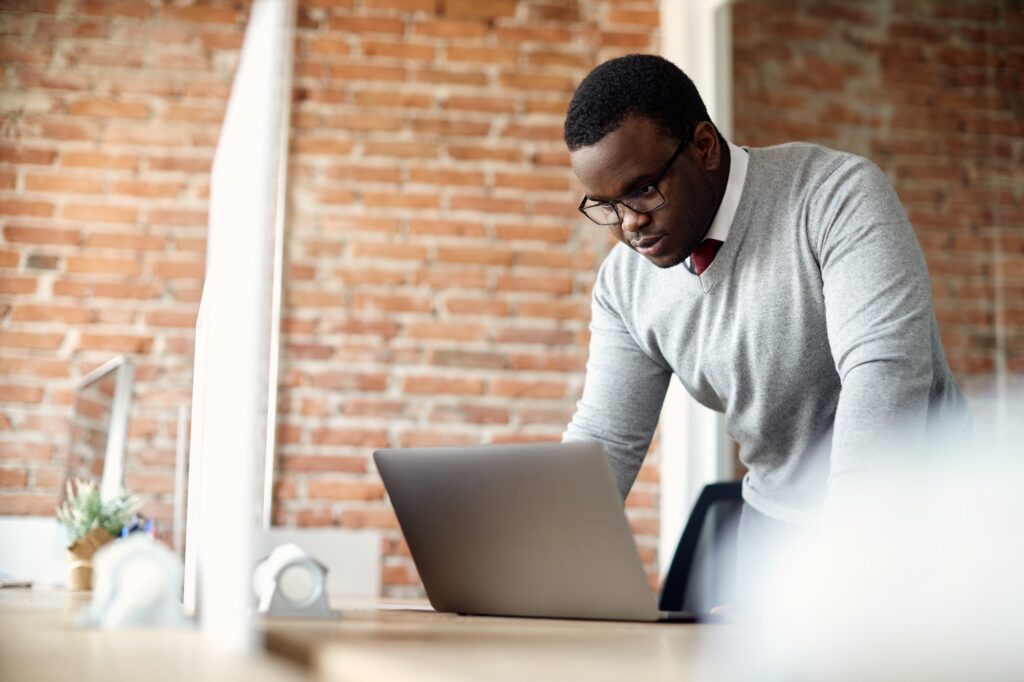 african american businessman reading an e mail on laptop in the office