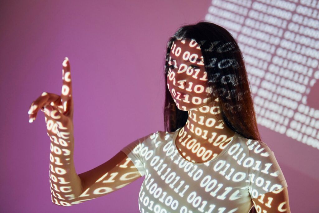 Binary machine code. Beautiful young woman is in projector neon lights in the studio